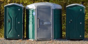 ada compliant porta potty between two regular porta potties